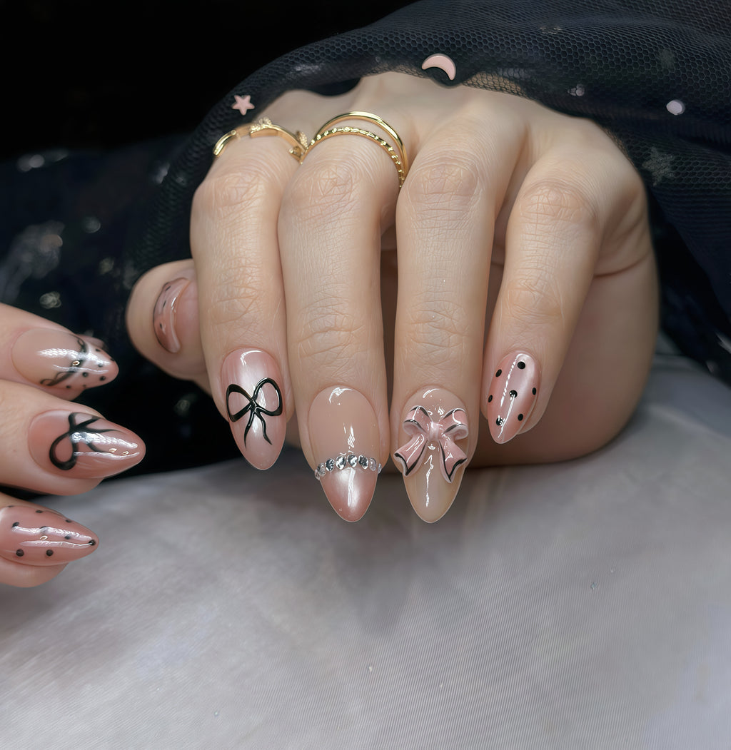 Pink Bow Mobster – Short Almond Press On Nails 🎀✨ | Nude Pink, Black Bow Art & Rhinestone Detail | Hand-Painted Gel Reusable Set, 30 Nails, 15 Sizes, Perfect Gift