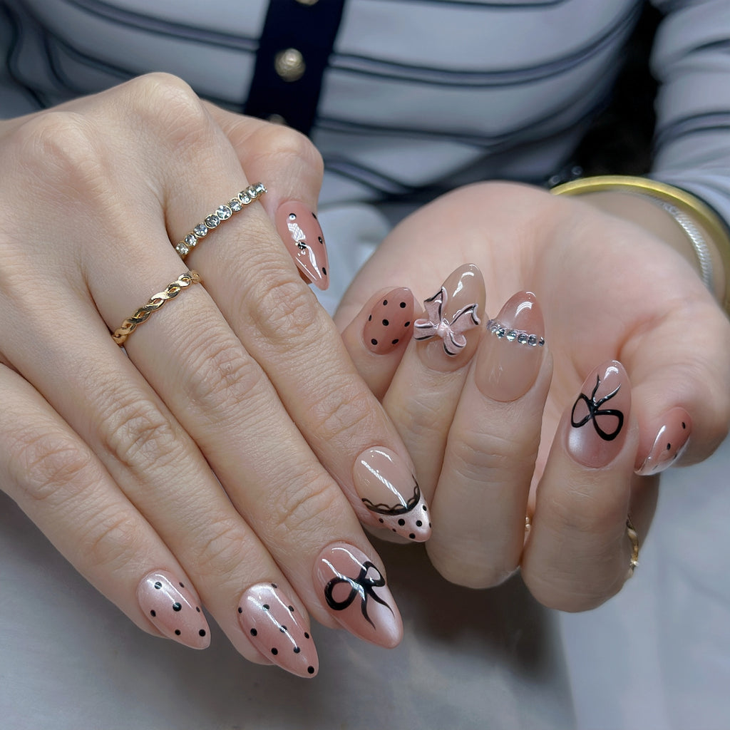 Pink Bow Mobster – Short Almond Press On Nails 🎀✨ | Nude Pink, Black Bow Art & Rhinestone Detail | Hand-Painted Gel Reusable Set, 30 Nails, 15 Sizes, Perfect Gift