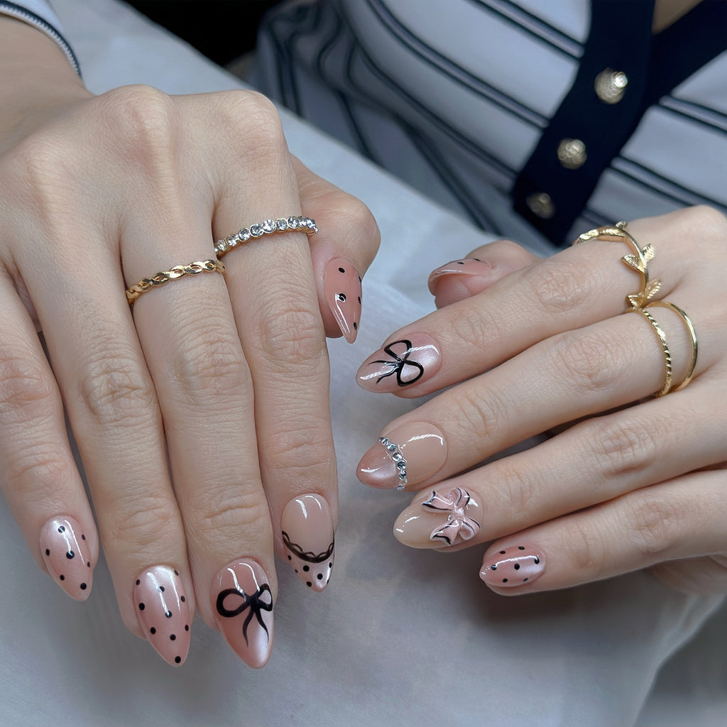 Pink Bow Mobster – Short Almond Press On Nails 🎀✨ | Nude Pink, Black Bow Art & Rhinestone Detail | Hand-Painted Gel Reusable Set, 30 Nails, 15 Sizes, Perfect Gift